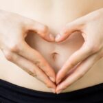 mujer manos dar forma corazón vientre