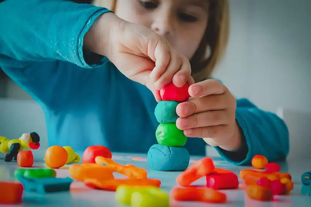 niña pequeña jugando plastilina